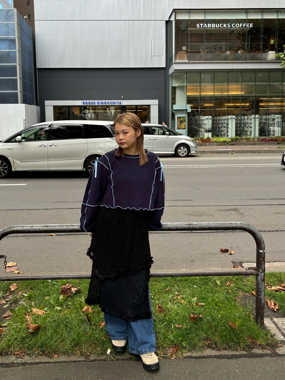 ブルー系のTシャツ/カットソー、ブラック系のスカート、ブルー系のデニムパンツを着用したレディースの秋コーディネートの2枚目の写真