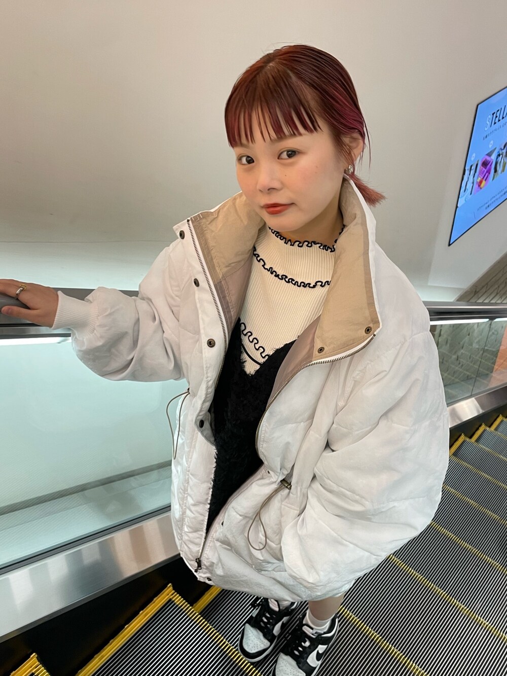 ブラック系のワンピース、ホワイト系のダウンジャケット/コート、ホワイト系のニット/セーターを着用したレディースの冬コーディネートの5枚目の写真