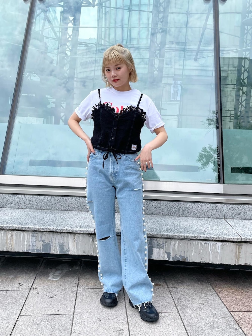 ホワイト系のTシャツ/カットソー、ブラック系のキャミソール、ブルー系のデニムパンツを着用したレディースの夏コーディネートの3枚目の写真