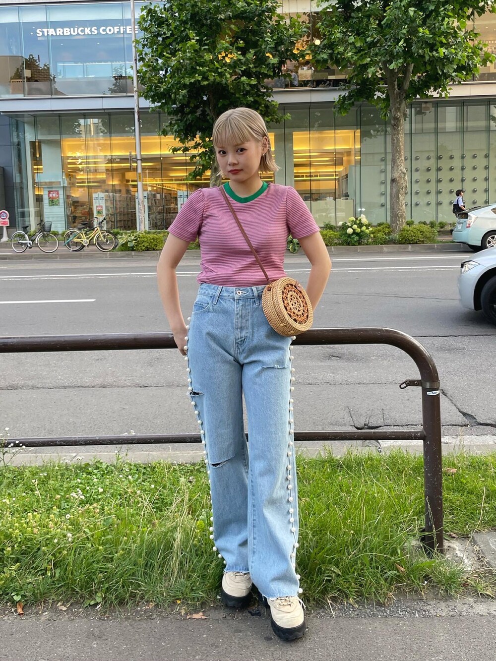 ブルー系のデニムパンツ、ベージュ系のかごバッグを着用したレディースの夏コーディネートの4枚目の写真