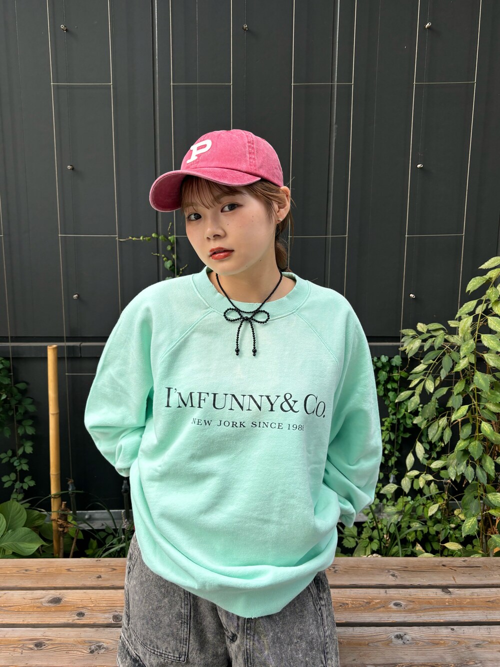 ブラック系のデニムパンツ、グリーン系のTシャツ/カットソー、ブラック系のネックレスを着用したレディースの秋コーディネートの3枚目の写真