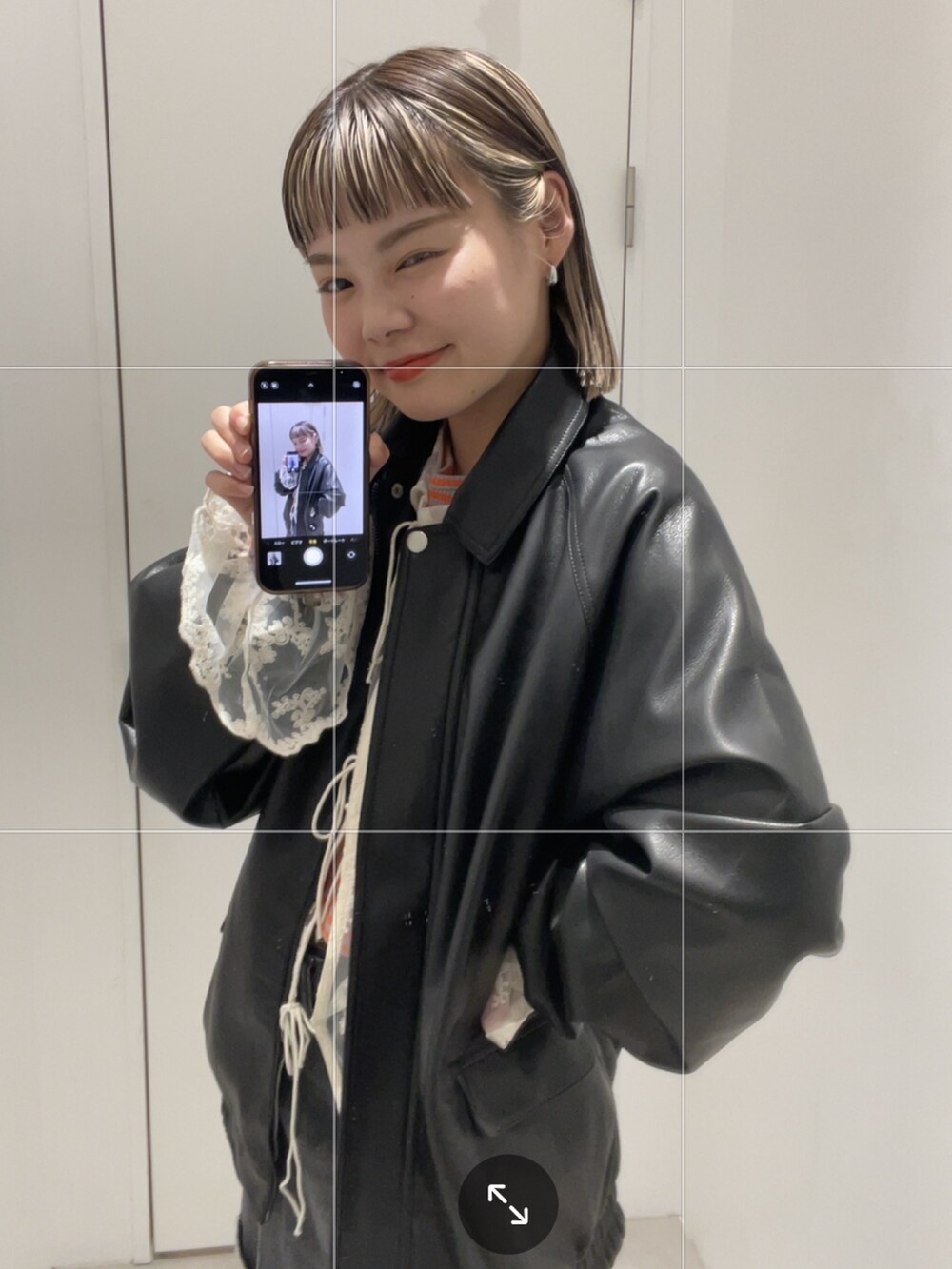 ブラック系のブルゾン、ホワイト系のシャツ/ブラウス、オレンジ系のTシャツ/カットソーを着用したレディースの秋コーディネートの2枚目の写真