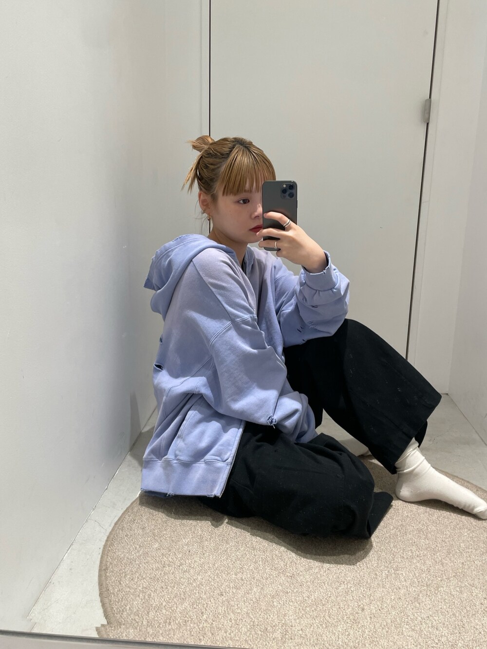 パープル系のパーカー、ブラック系のカーゴパンツを着用したレディースの春コーディネートの3枚目の写真