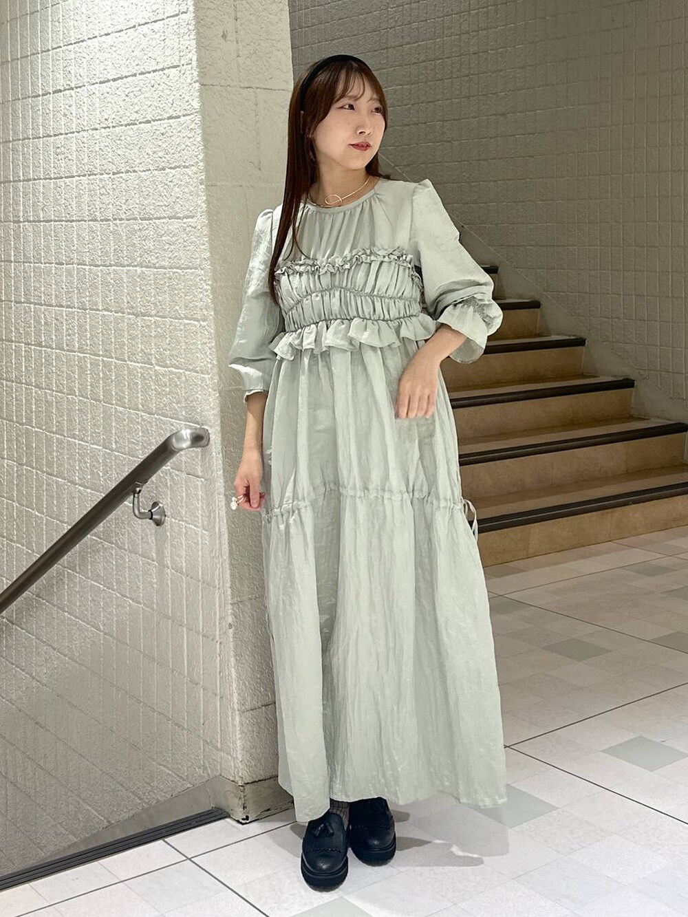 グリーン系のドレスを着用したレディースの秋コーディネートの7枚目の写真