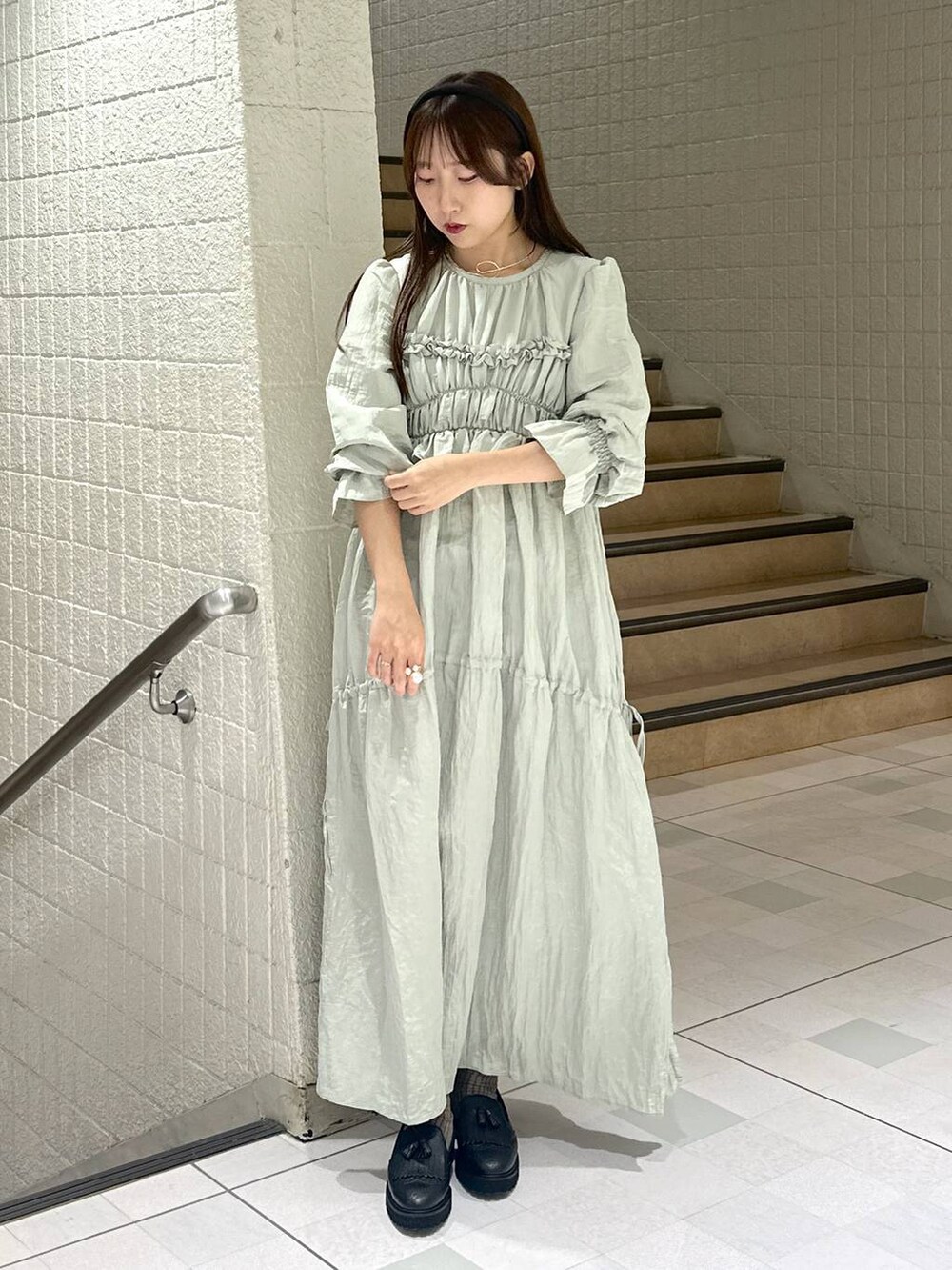 グリーン系のドレスを着用したレディースの秋コーディネートの5枚目の写真