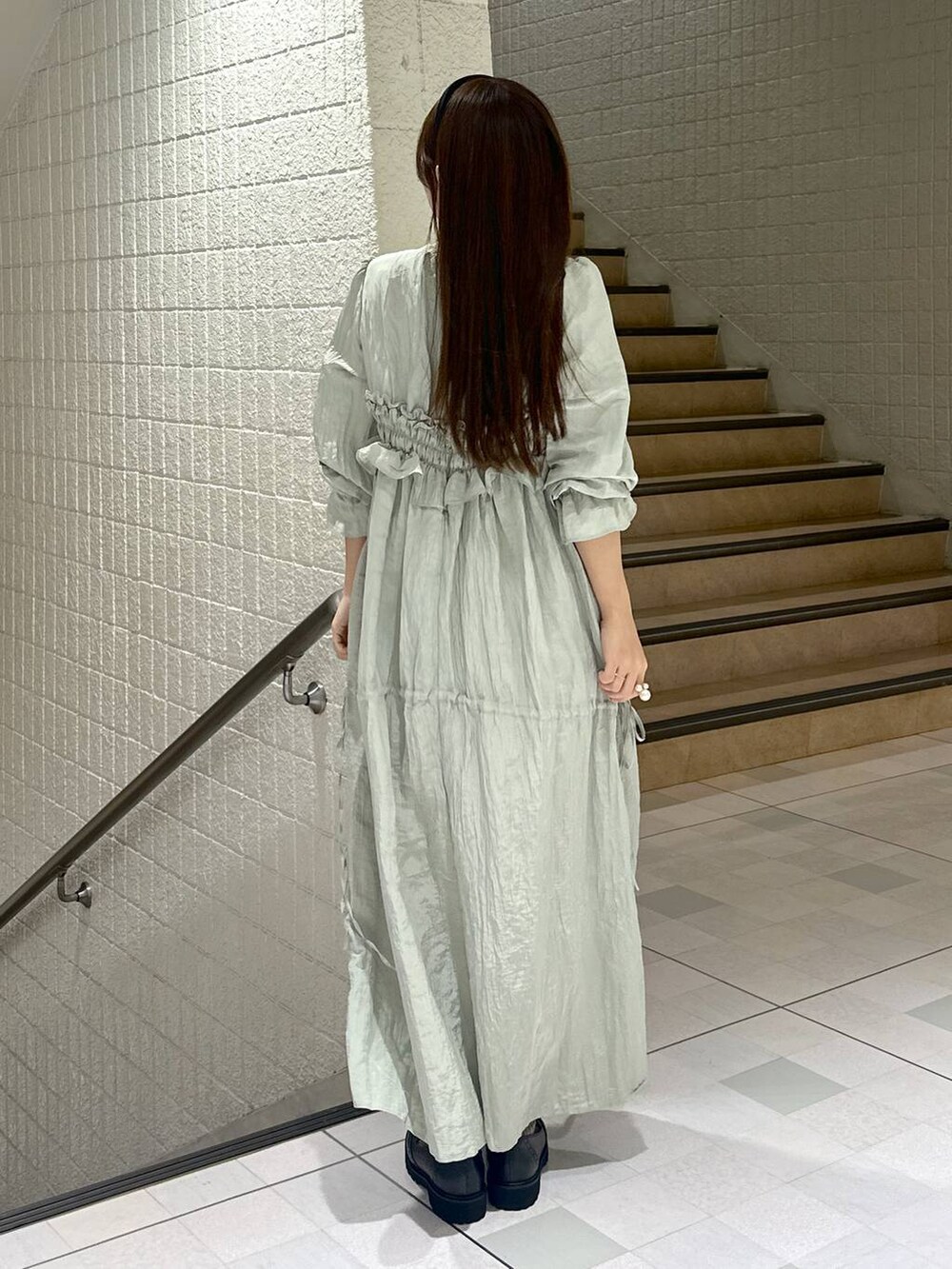 グリーン系のドレスを着用したレディースの秋コーディネートの4枚目の写真