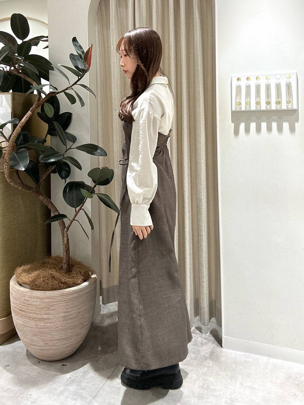 ブラック系のブーツ、ブラウン系のワンピースを着用したレディースの秋コーディネートの2枚目の写真