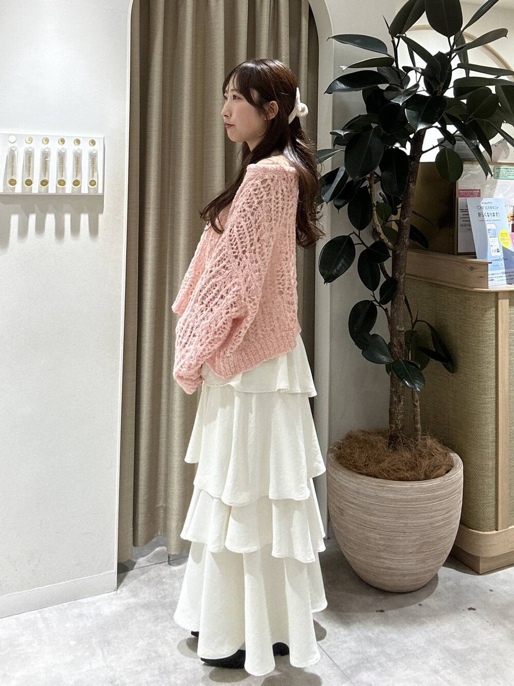 ブラック系のパンプス、ピンク系のニット/セーター、ホワイト系のスカートを着用したレディースの冬コーディネートの3枚目の写真