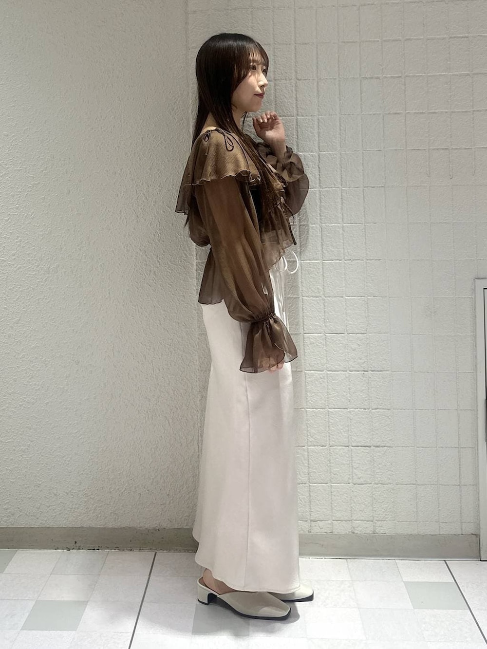ホワイト系のスリッポン、ブラウン系のシャツ/ブラウス、ホワイト系のスカートを着用したレディースの春コーディネートの2枚目の写真