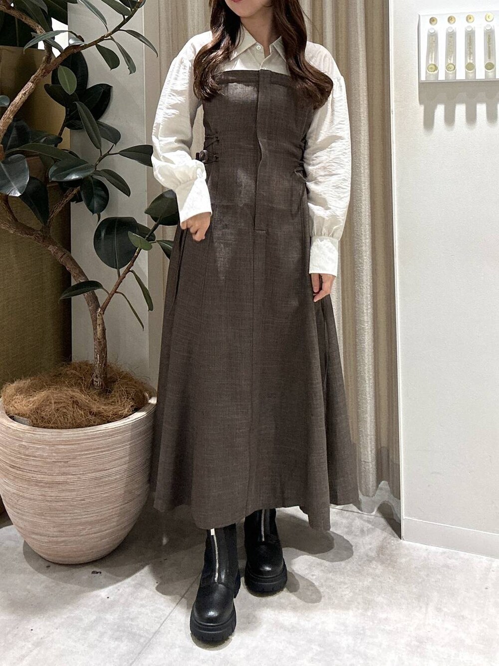 ブラック系のブーツ、ブラウン系のワンピースを着用したレディースの秋コーディネートの4枚目の写真