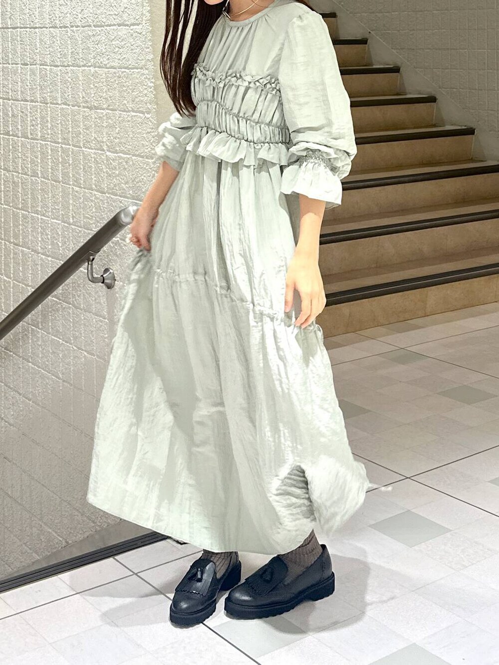 グリーン系のドレスを着用したレディースの秋コーディネートの2枚目の写真