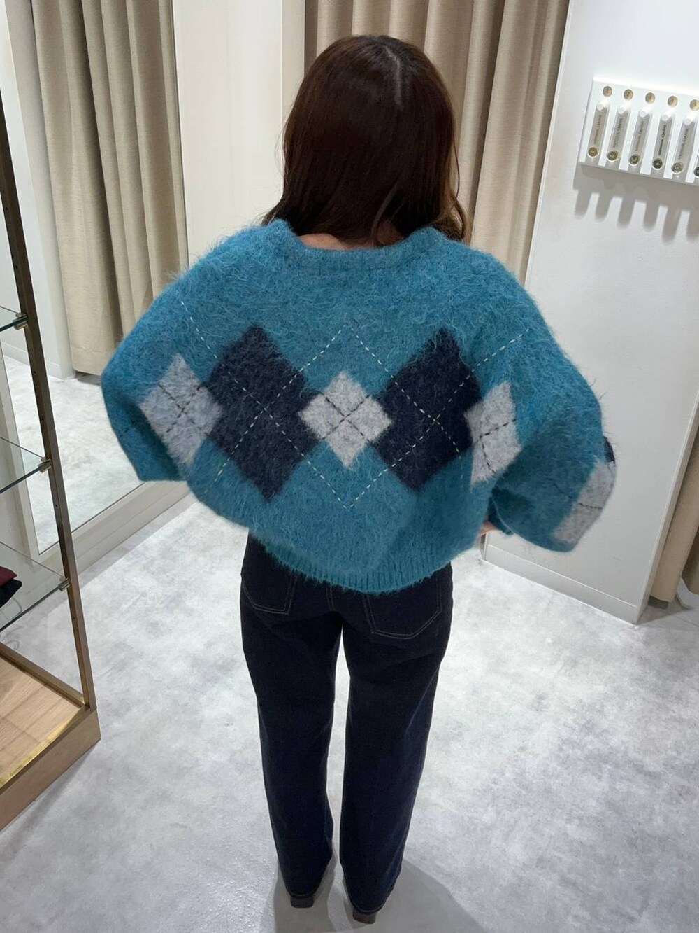 ブルー系のカーディガン/ボレロ、ブルー系のデニムパンツ、ブラウン系のブーツを着用したレディースの秋コーディネートの3枚目の写真