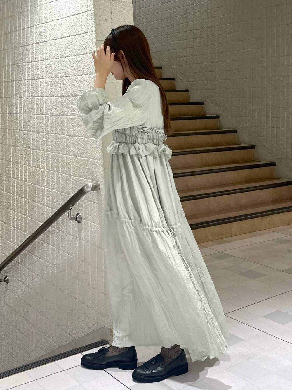 グリーン系のドレスを着用したレディースの秋コーディネートの6枚目の写真