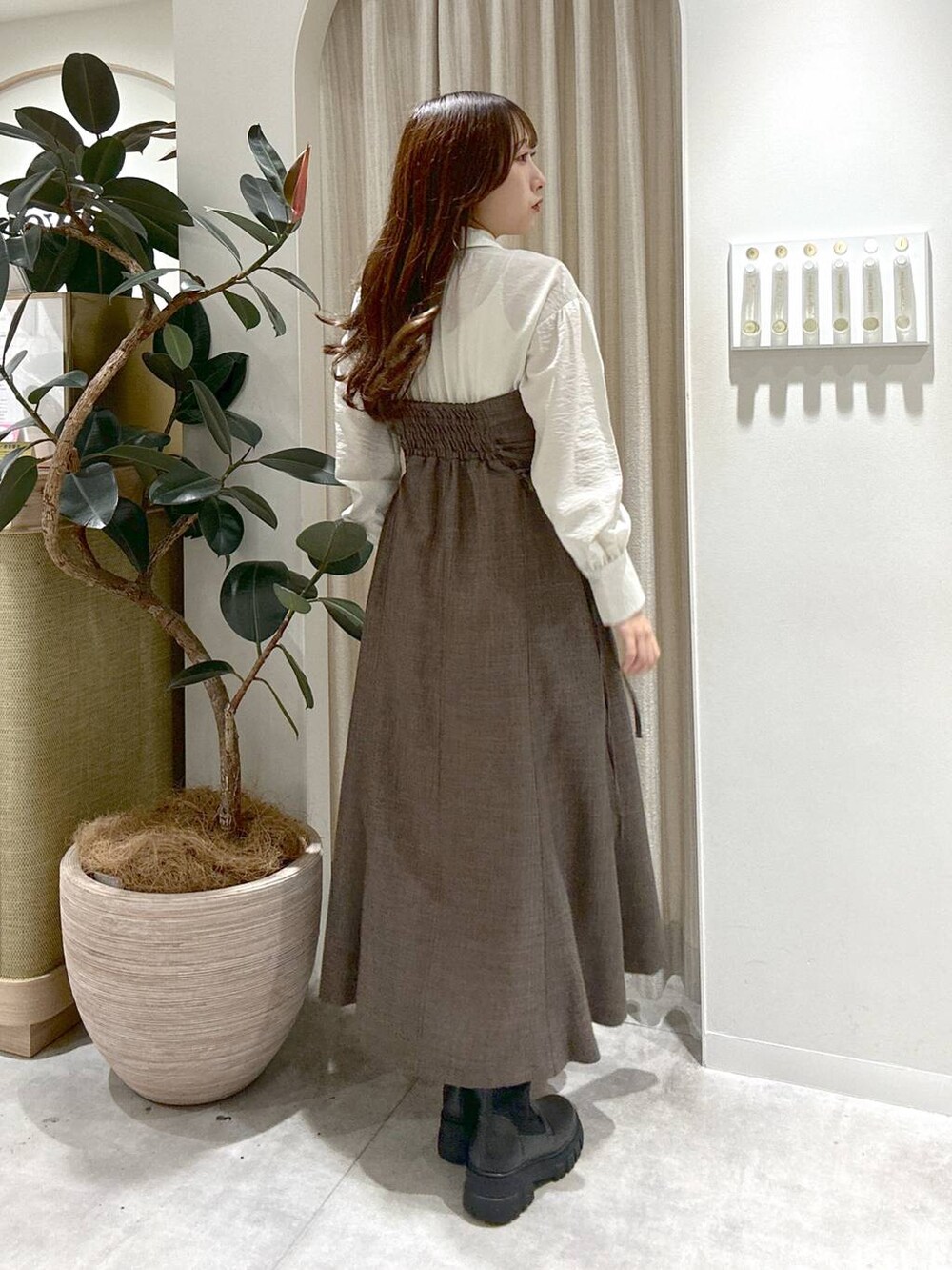 ブラック系のブーツ、ブラウン系のワンピースを着用したレディースの秋コーディネートの3枚目の写真