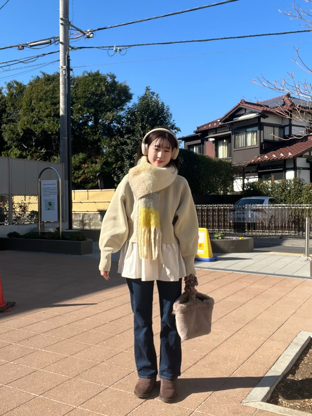 ホワイト系のブルゾン、ホワイト系のカーディガン/ボレロ、ブルー系のデニムパンツを着用したレディースの冬コーディネートの2枚目の写真