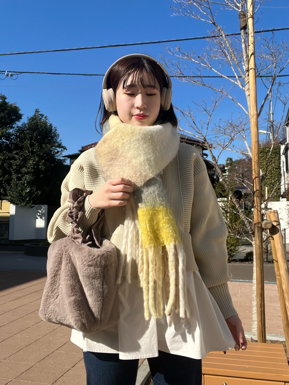ホワイト系のブルゾン、ホワイト系のカーディガン/ボレロ、ブルー系のデニムパンツを着用したレディースの冬コーディネートの4枚目の写真