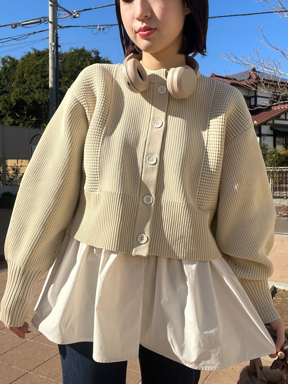 ホワイト系のブルゾン、ホワイト系のカーディガン/ボレロ、ブルー系のデニムパンツを着用したレディースの冬コーディネートの3枚目の写真