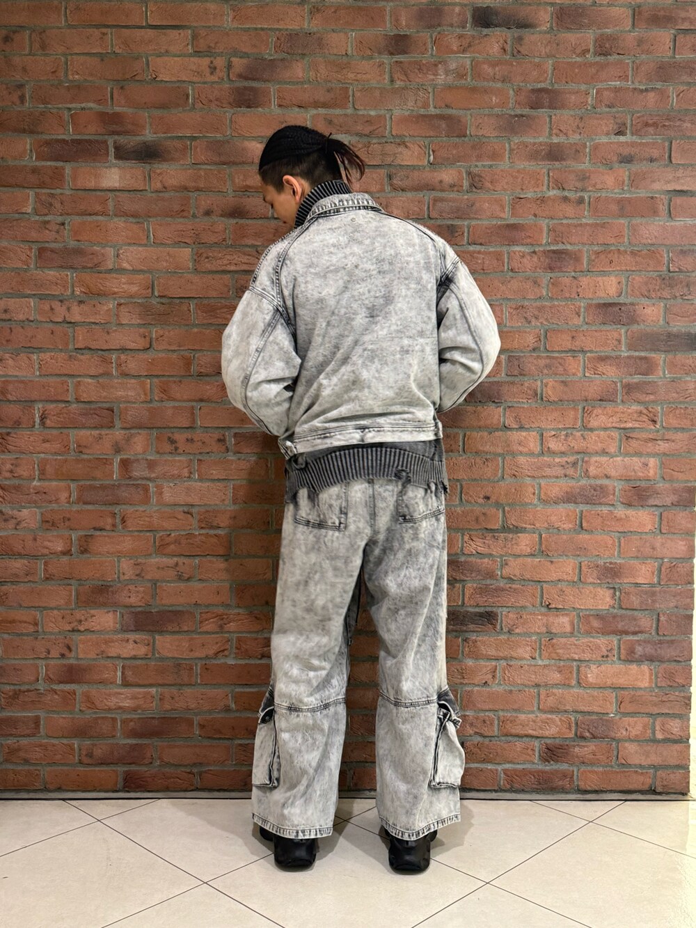 ブラック系のデニムパンツ、ブラック系のニット/セーター、ブラック系のジャケット/アウターを着用したメンズの秋コーディネートの2枚目の写真