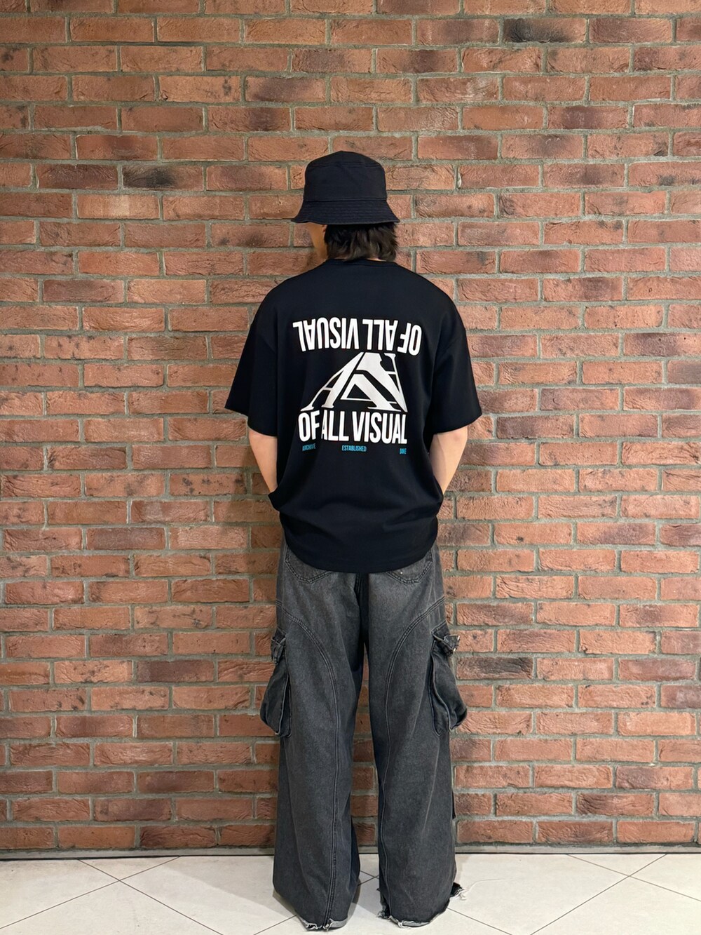 ブラック系のTシャツ/カットソー、ブラック系のハットを着用したメンズの春コーディネートの2枚目の写真