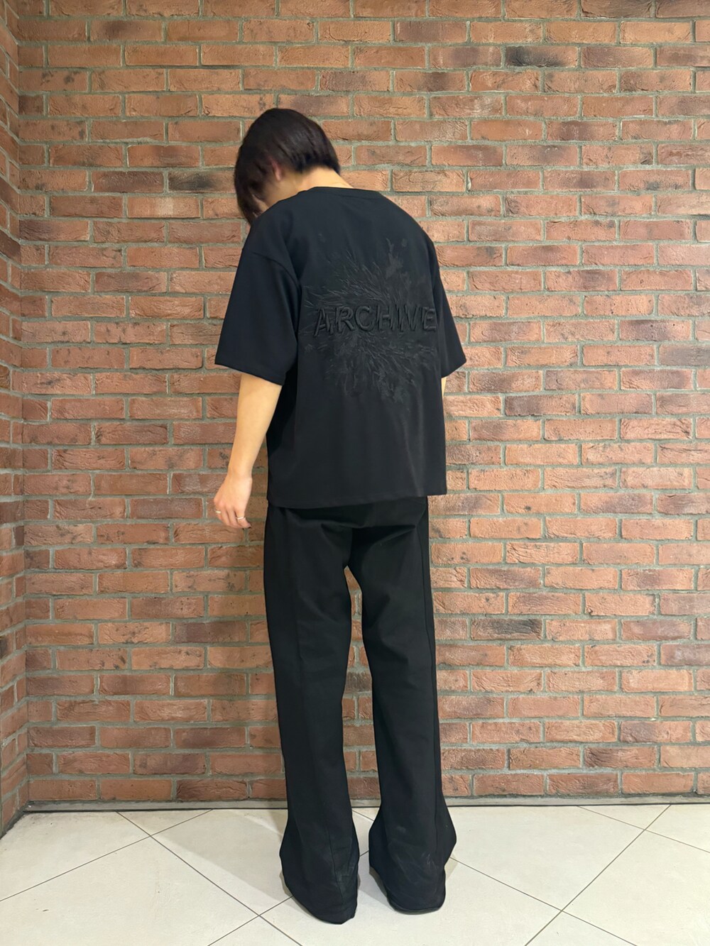 ブラック系のTシャツ/カットソーを着用したメンズの春コーディネートの2枚目の写真