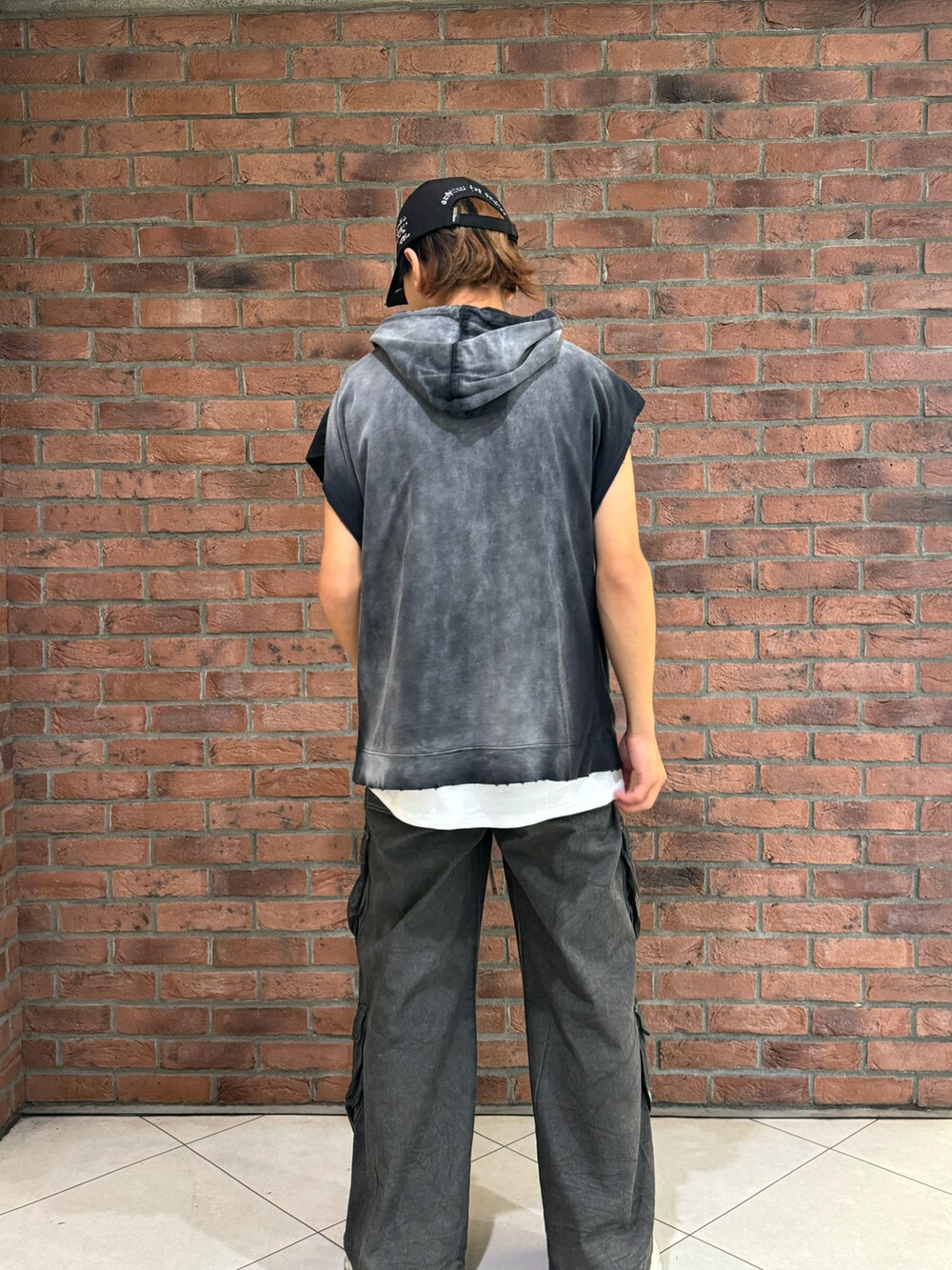 ブラック系のカーゴパンツ、ブラック系のパーカー、ブラック系のキャップを着用したメンズの夏コーディネートの2枚目の写真