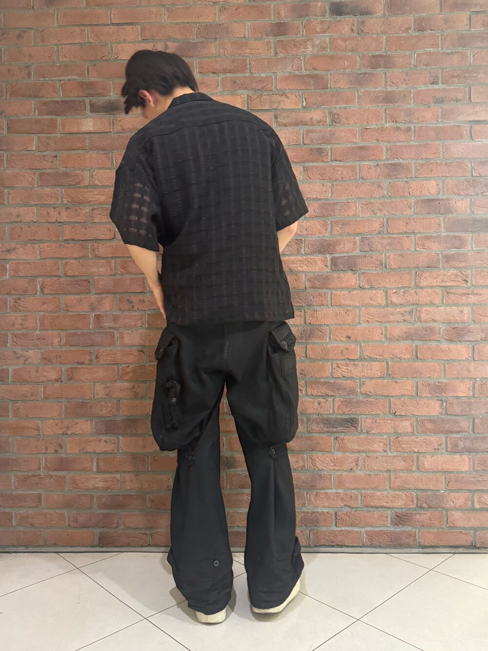 ブラック系のシャツ/ブラウス、ブラック系のカーゴパンツ、ブラック系のシューズを着用したメンズの春コーディネートの2枚目の写真