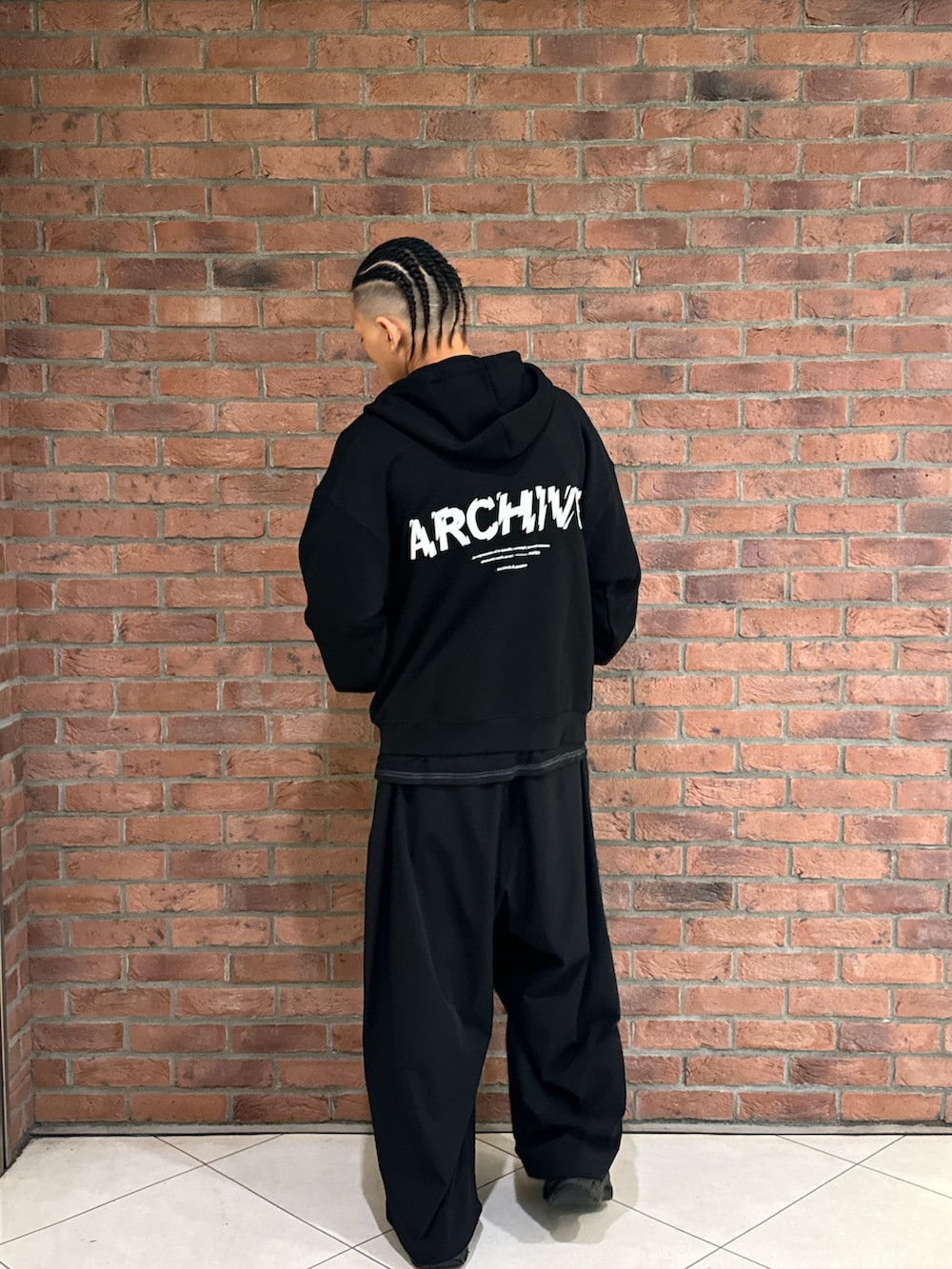 レッド系のTシャツ/カットソー、ブラック系のパーカー、ブラック系のその他パンツを着用したメンズの秋コーディネートの2枚目の写真