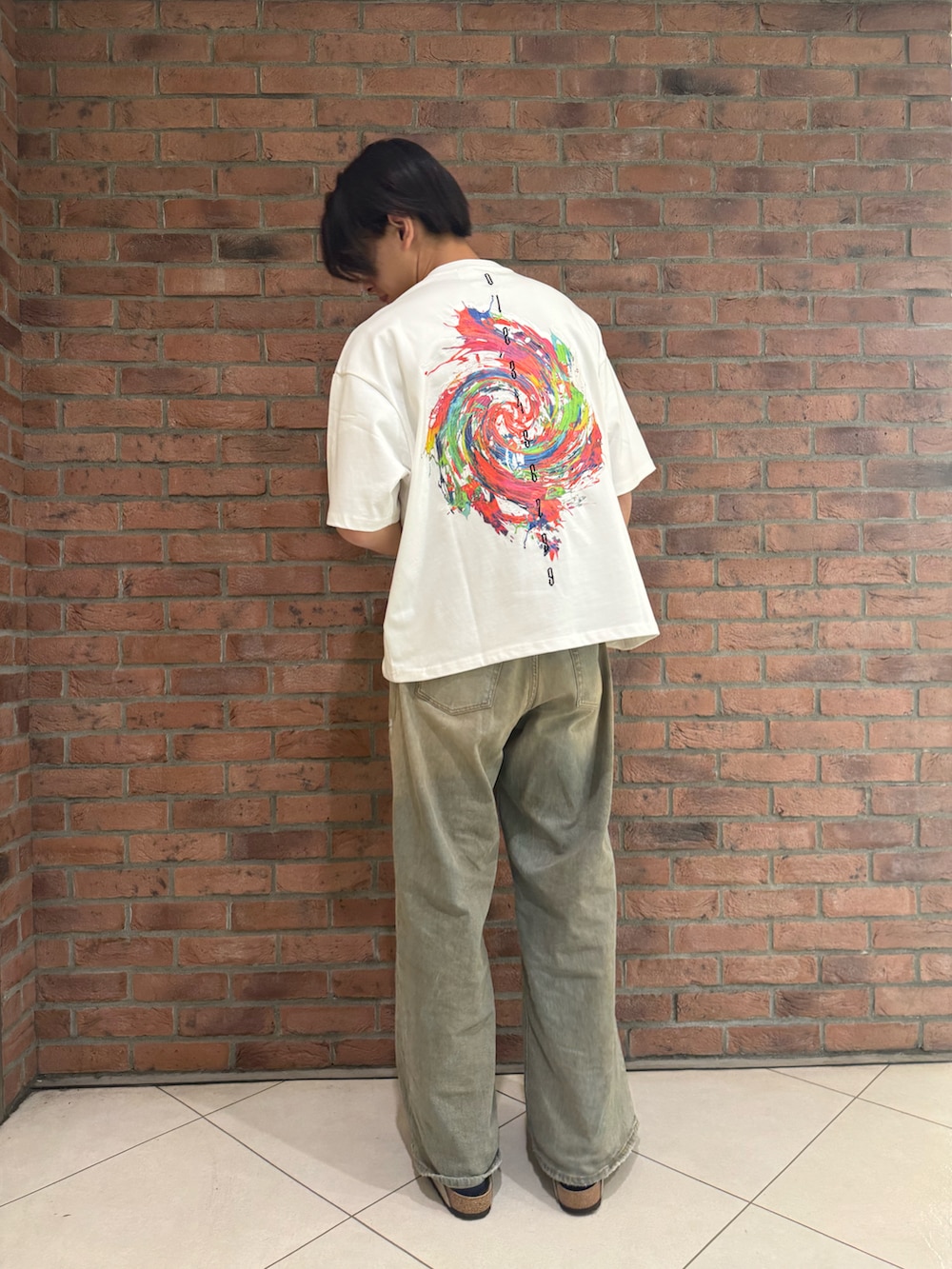 ホワイト系のTシャツ/カットソー、ブルー系のデニムパンツ、ベージュ系のサンダルを着用したメンズの春コーディネートの2枚目の写真
