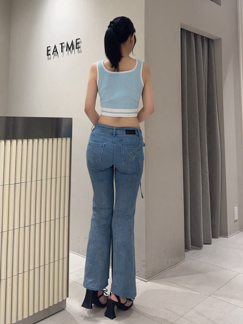 ブラック系のサンダル、ブルー系のタンクトップ、ブルー系のデニムパンツを着用したレディースの夏コーディネートの4枚目の写真