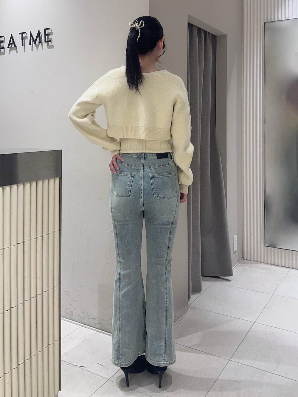 イエロー系のニット/セーター、ブルー系のデニムパンツ、ブラック系のブーツを着用したレディースの冬コーディネートの3枚目の写真