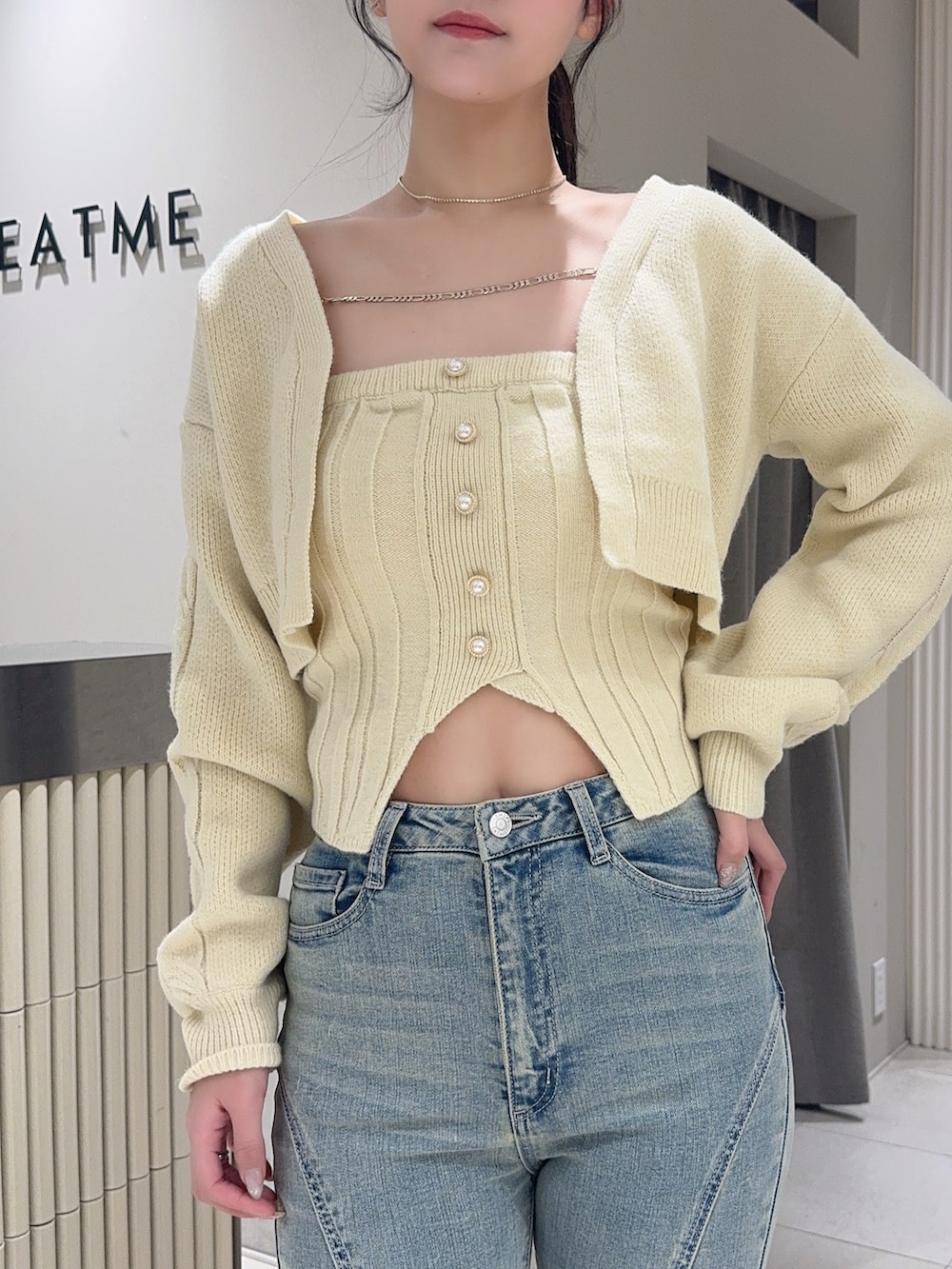 イエロー系のニット/セーター、ブルー系のデニムパンツ、ブラック系のブーツを着用したレディースの冬コーディネートの4枚目の写真