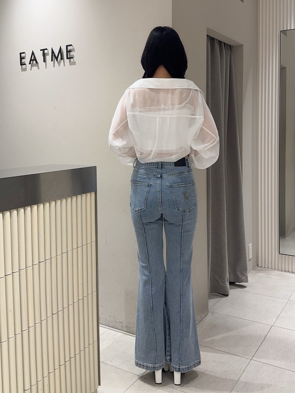 ブルー系のデニムパンツ、ホワイト系のブーツ、ホワイト系のシャツ/ブラウスを着用したレディースの春コーディネートの3枚目の写真