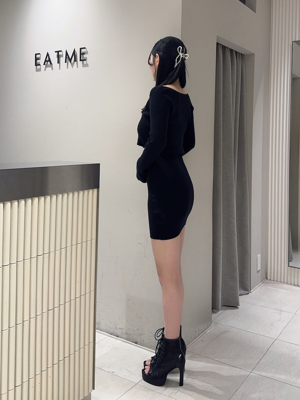 ブラック系のブーツ、ブラック系のワンピース、ゴールド系のバレッタ/ヘアクリップを着用したレディースの冬コーディネートの3枚目の写真