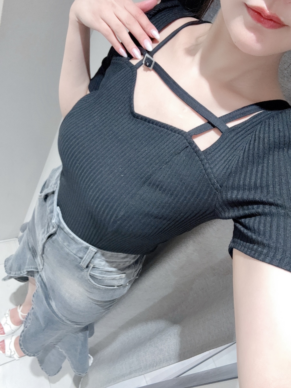 ブラック系のTシャツ/カットソー、ブラック系のデニムスカート、ホワイト系のサンダルを着用したレディースの夏コーディネートの4枚目の写真