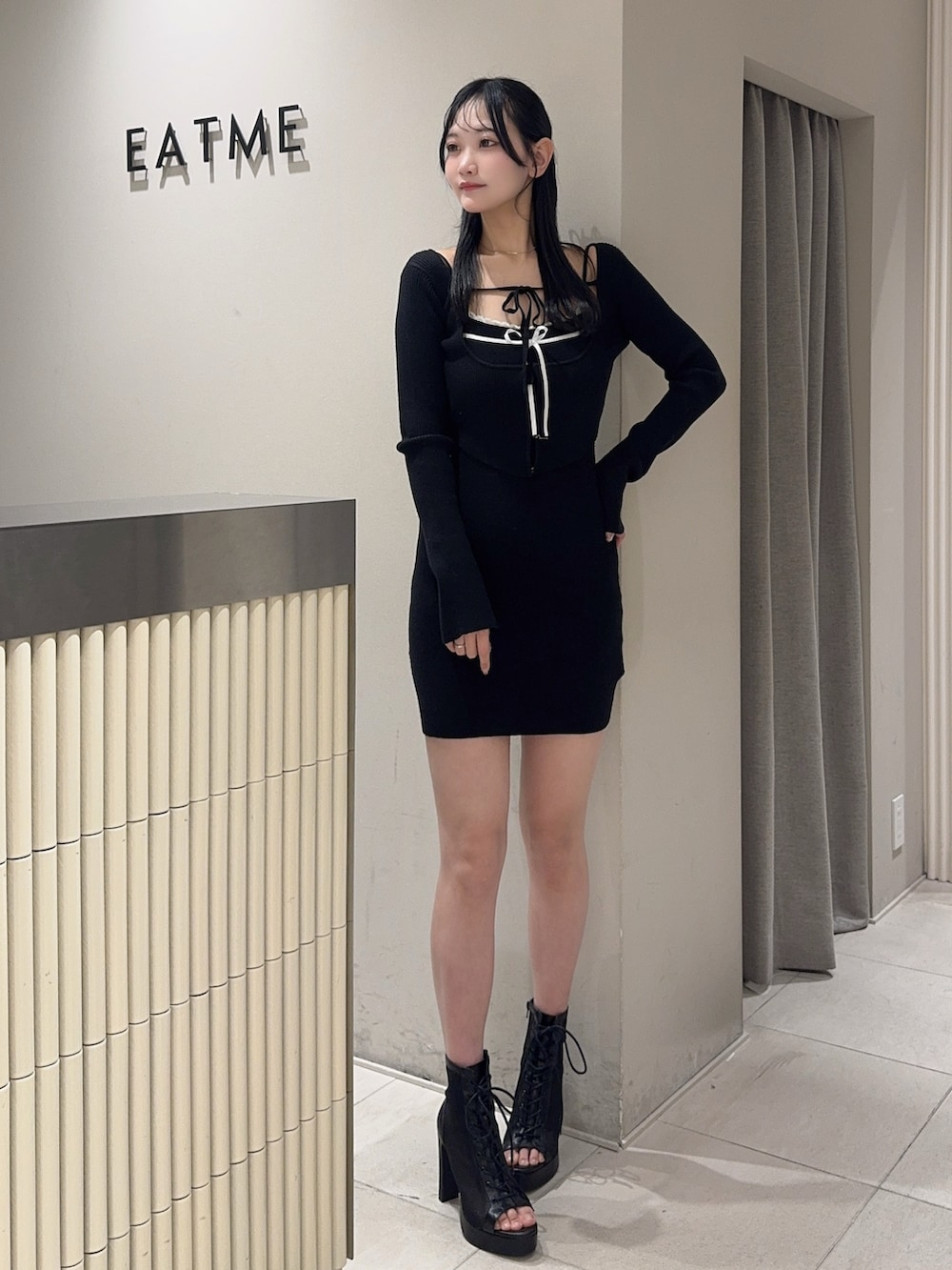 ブラック系のブーツ、ブラック系のワンピース、ゴールド系のバレッタ/ヘアクリップを着用したレディースの冬コーディネートの2枚目の写真