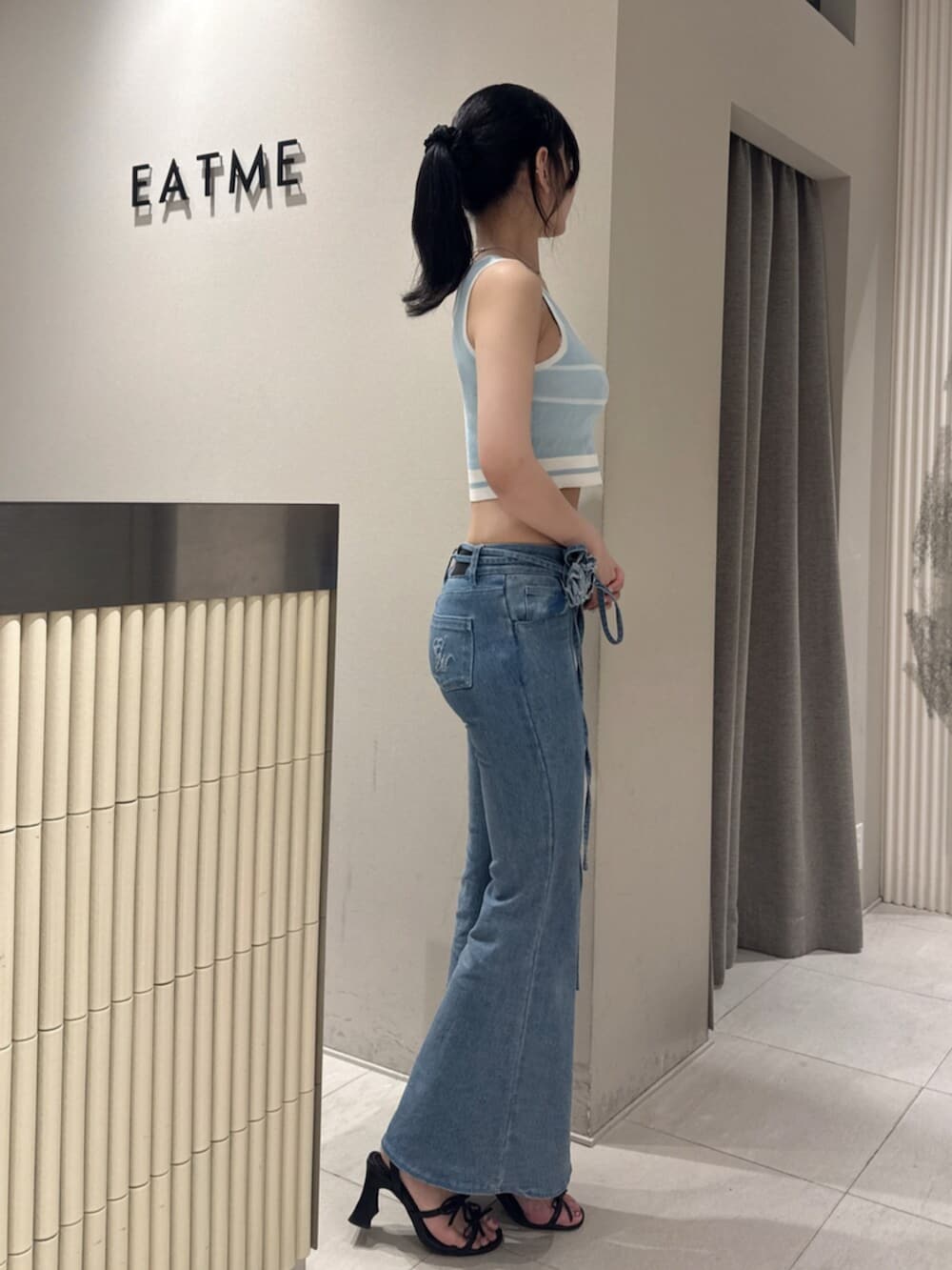 ブラック系のサンダル、ブルー系のタンクトップ、ブルー系のデニムパンツを着用したレディースの夏コーディネートの3枚目の写真