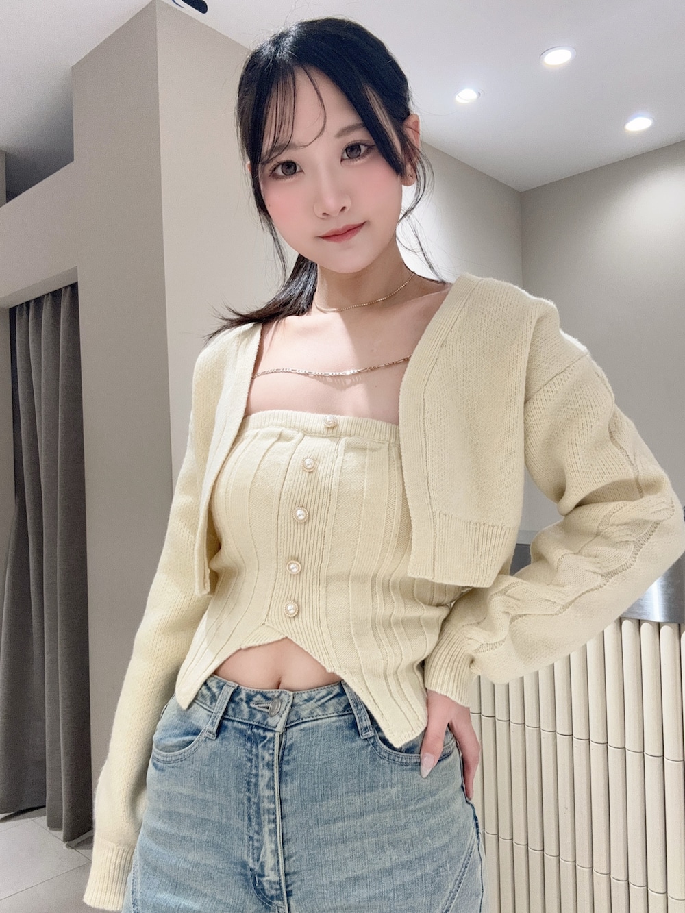 イエロー系のニット/セーター、ブルー系のデニムパンツ、ブラック系のブーツを着用したレディースの冬コーディネートの5枚目の写真