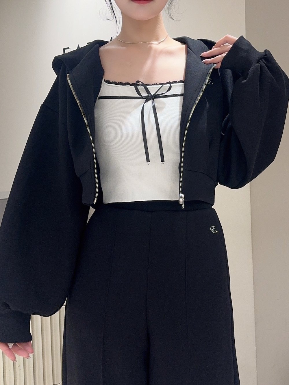 ブラック系のその他パンツ、ホワイト系のニット/セーター、ブラック系のパーカーを着用したレディースの冬コーディネートの5枚目の写真