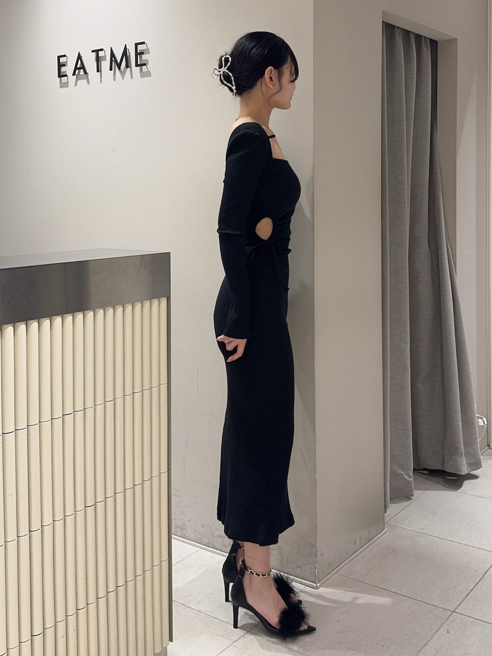 ブラック系のワンピース、ホワイト系のハンドバッグ、ブラック系のサンダルを着用したレディースの春コーディネートの2枚目の写真