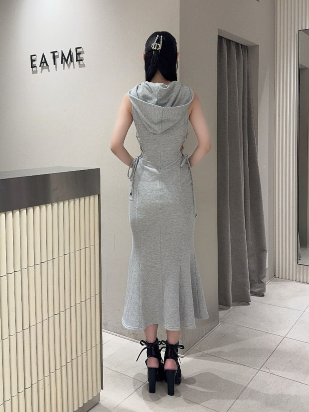 ブラック系のサンダル、グレー系のワンピース、ゴールド系のバレッタ/ヘアクリップを着用したレディースの夏コーディネートの3枚目の写真