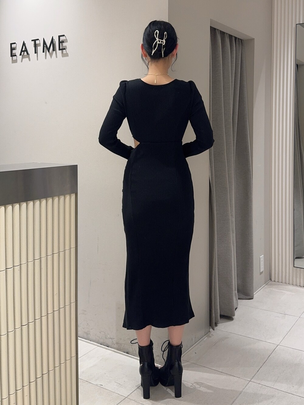 ブラック系のワンピース、ブラック系のブーツ、ゴールド系のネックレスを着用したレディースの冬コーディネートの4枚目の写真