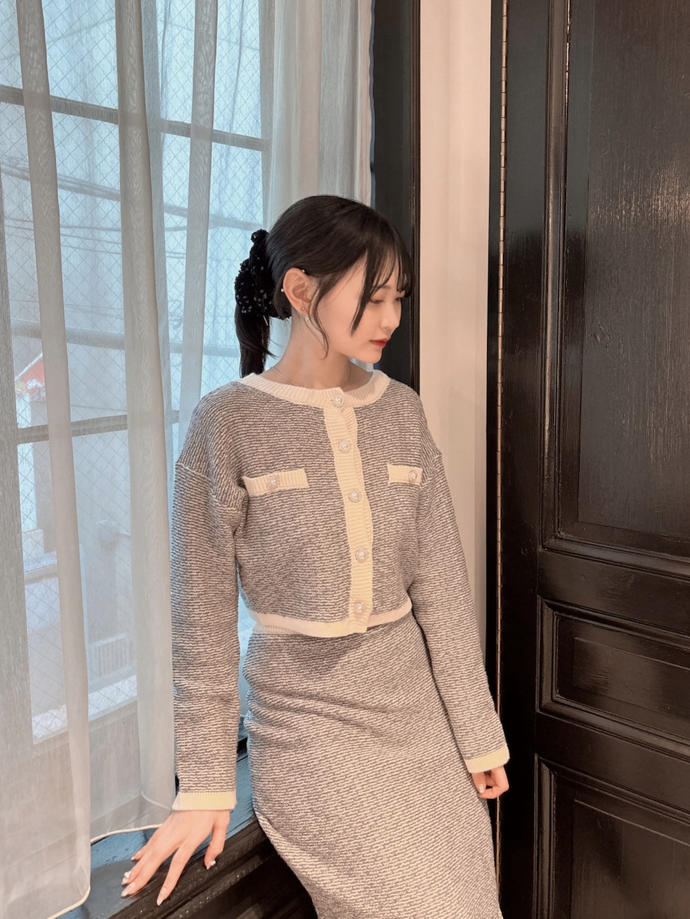 ブルー系のカーディガン/ボレロ、ブルー系のスカート、ブラック系のパンプスを着用したレディースの冬コーディネートの4枚目の写真