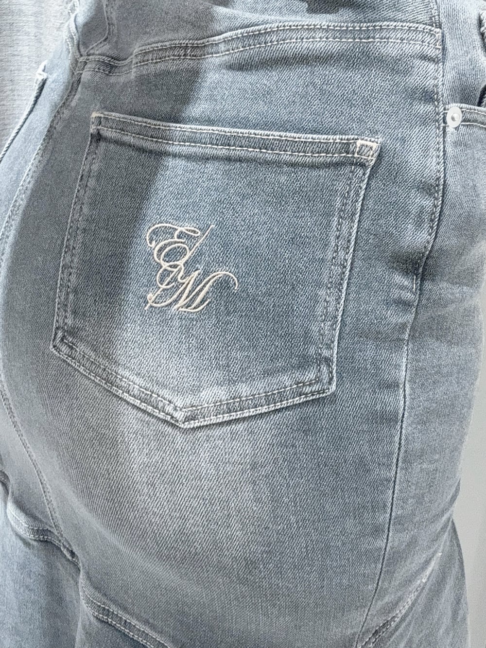 ブラック系のTシャツ/カットソー、ブラック系のデニムスカート、ホワイト系のサンダルを着用したレディースの夏コーディネートの6枚目の写真