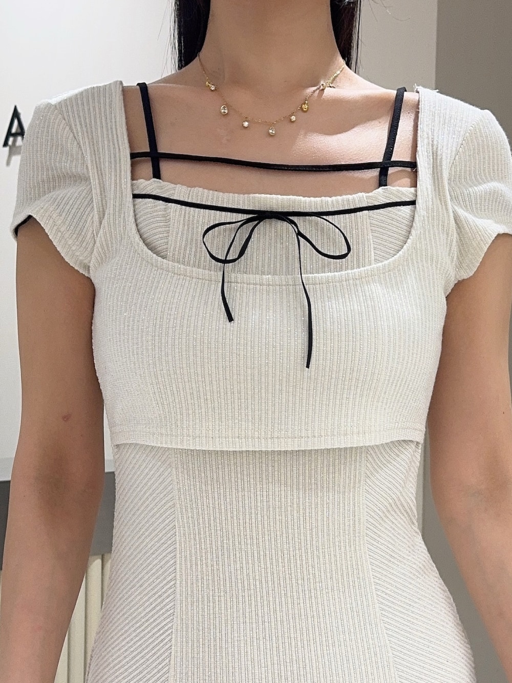 ホワイト系のワンピース、ブラック系のハンドバッグ、ブラック系のサンダルを着用したレディースの夏コーディネートの5枚目の写真