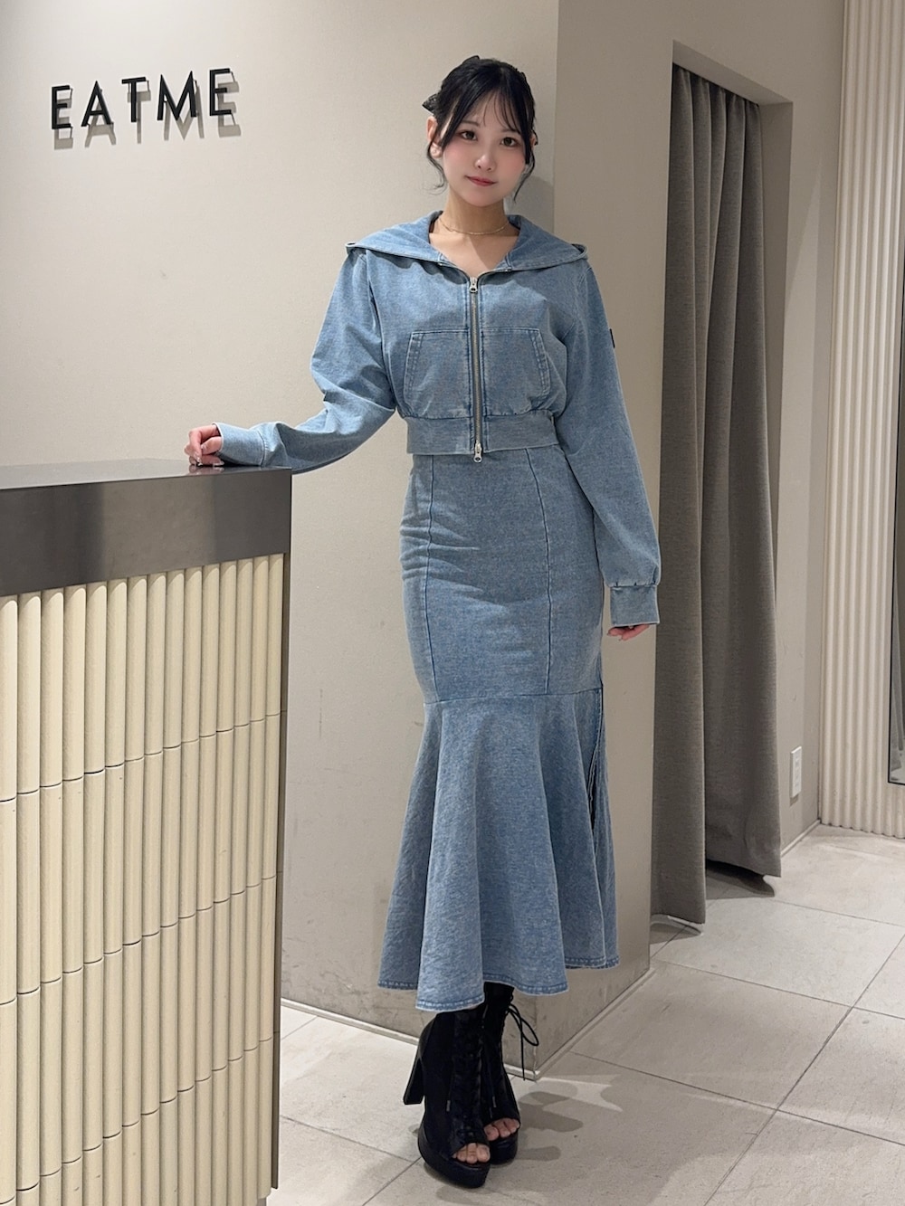 ブルー系のワンピース、ブルー系のパーカー、ブラック系のブーツを着用したレディースの春コーディネートの4枚目の写真