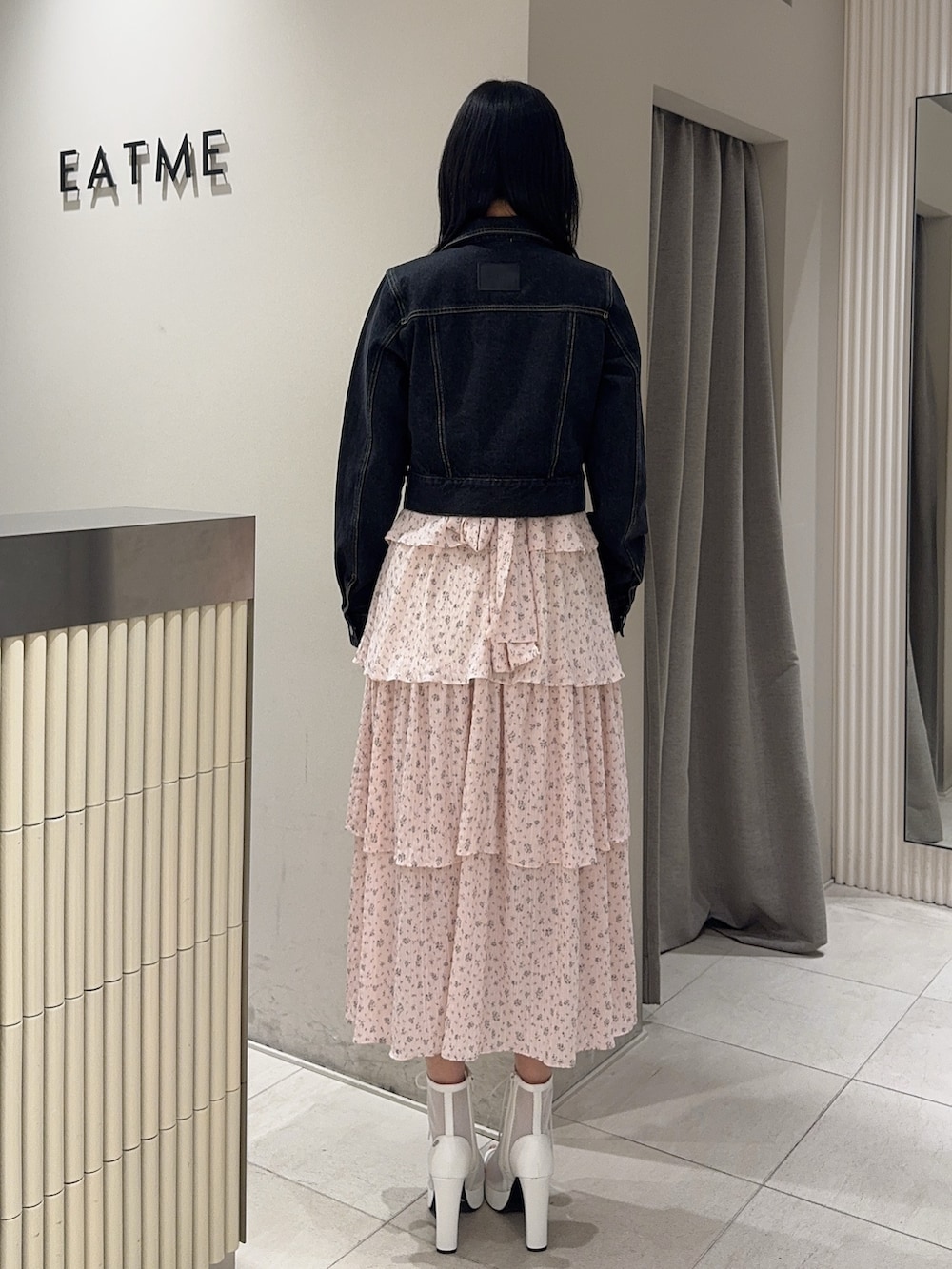 ピンク系のワンピース、ブラック系のデニムジャケット、ホワイト系のブーツを着用したレディースの春コーディネートの3枚目の写真