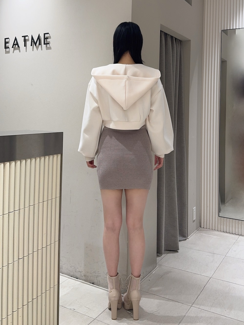 ベージュ系のワンピース、ホワイト系のパーカー、ベージュ系のブーツを着用したレディースの冬コーディネートの3枚目の写真