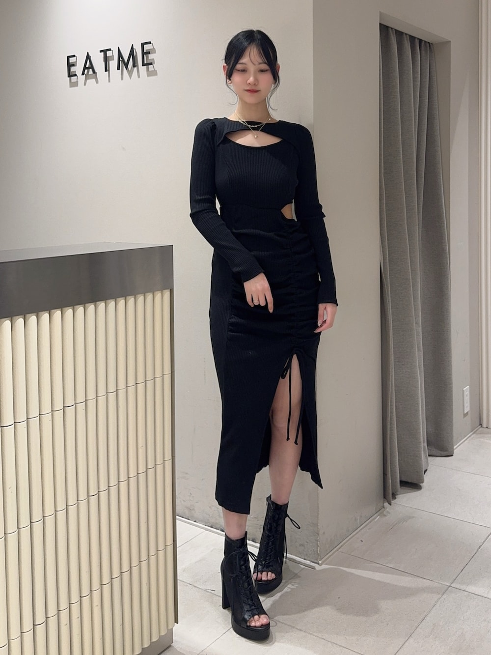 ブラック系のワンピース、ブラック系のブーツ、ゴールド系のネックレスを着用したレディースの冬コーディネートの2枚目の写真