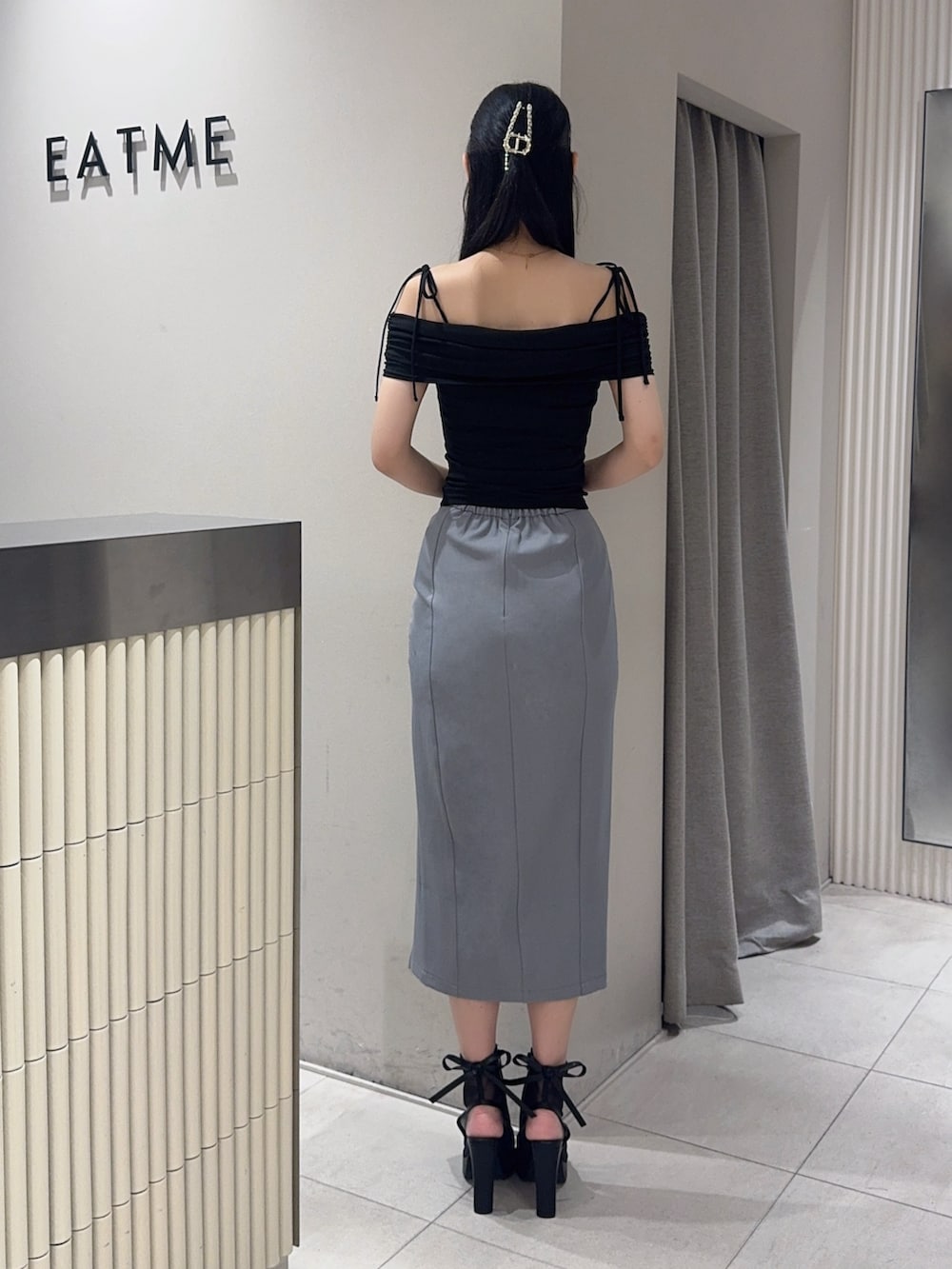 ブラック系のサンダル、グレー系のスカート、ブラック系のTシャツ/カットソーを着用したレディースの夏コーディネートの3枚目の写真