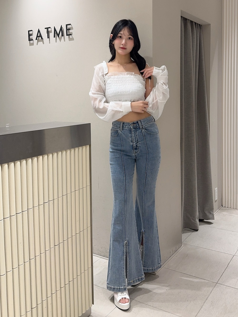 ブルー系のデニムパンツ、ホワイト系のブーツ、ホワイト系のシャツ/ブラウスを着用したレディースの春コーディネートの4枚目の写真